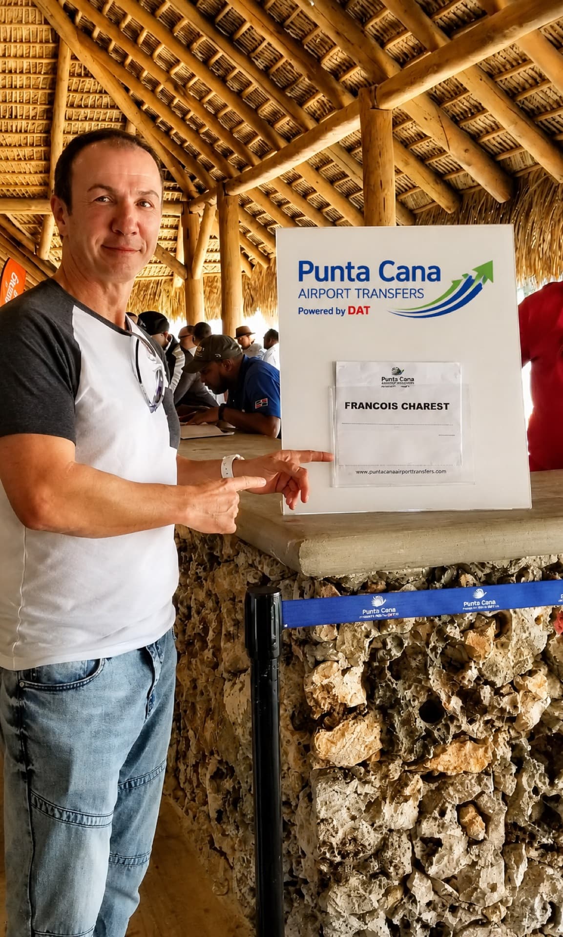 A traveler at the Punta Cana Airport Transfers meeting point beside a guest name sign